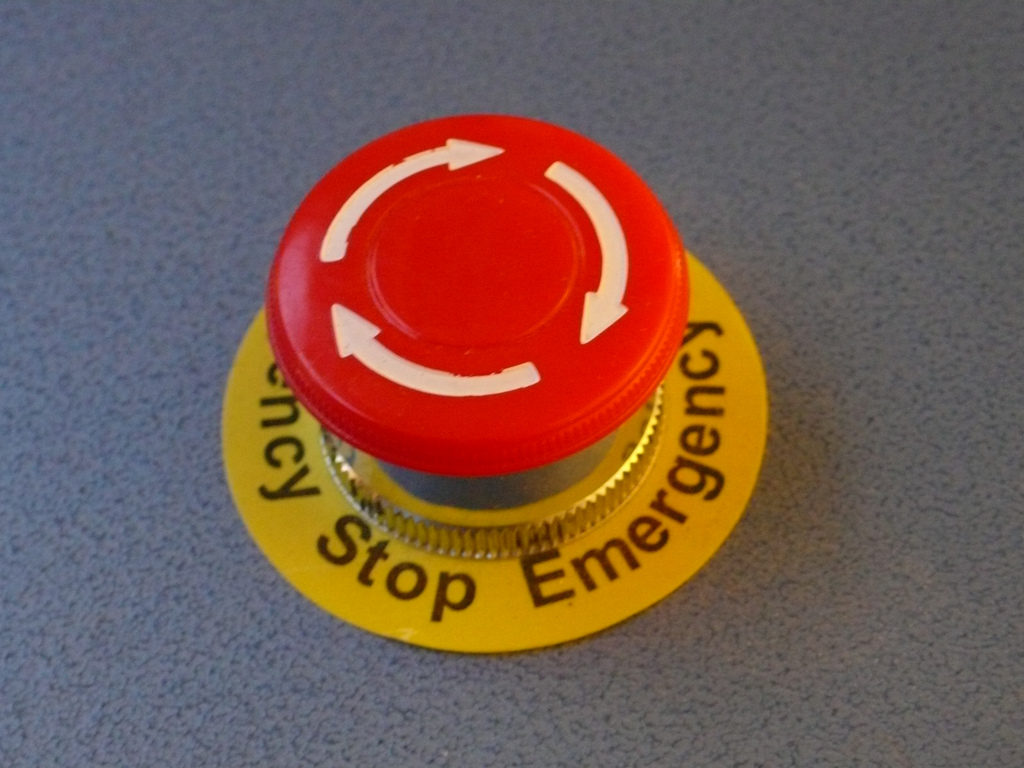 A red emergency stop button that would be present throughout a factory for use in an emergency to stop the factory.