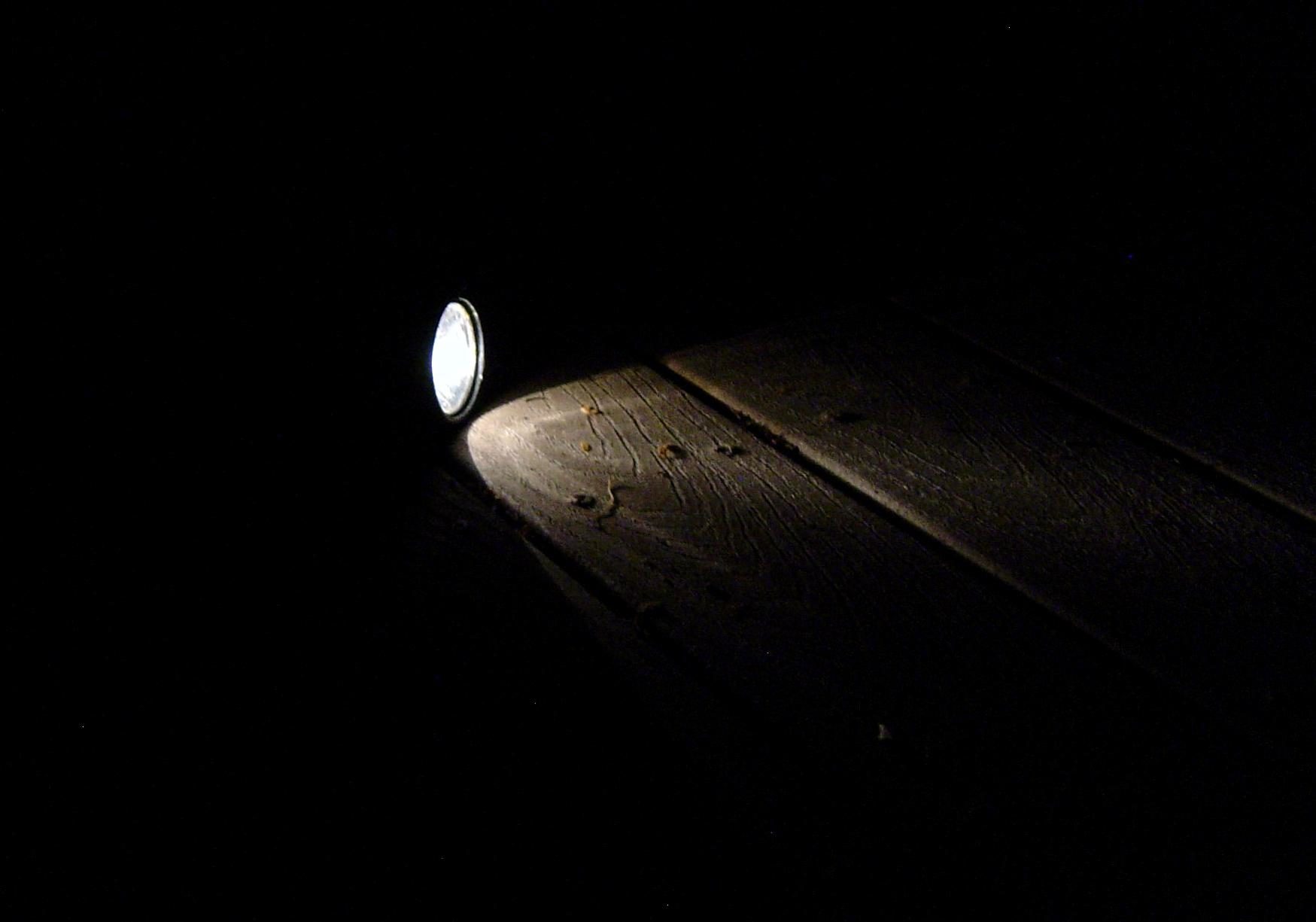 An image of a flashlight shining in a dark room.